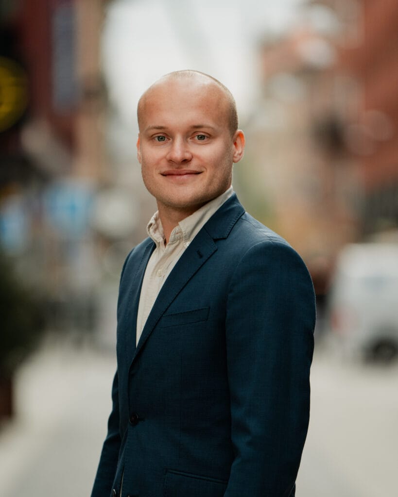 Professionell man i kostym som representerar Juni Strategis expertis inom bostadsmarknadsanalys och mäklardata