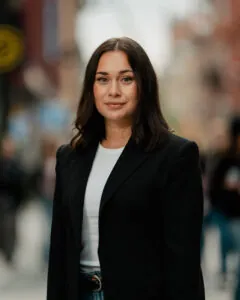 Kvinna i affärskläder står på stadsgata, representerar professionell rådgivning inom stadsutveckling