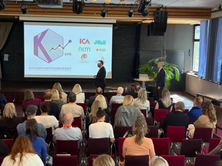 Presentation om Konsumtionsprognosrådet för publik i konferensrum med KPR-logotyp och samarbetspartners på skärm